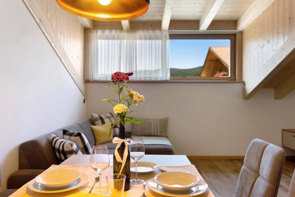 a dining room with a table with a vase of flowers at Living Lerchna - Schöne Aussicht 2 in Maranza