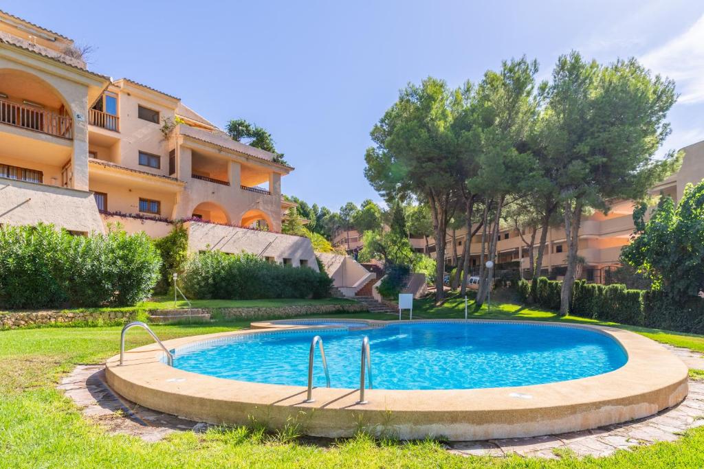 a swimming pool in a yard in front of a building at Simplicity luxury apartment in Altea