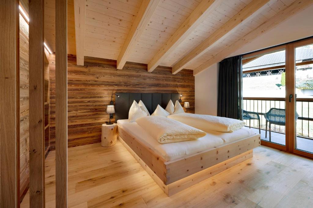 a bedroom with a bed with a wooden wall at Leierhof Brimella in Rodengo