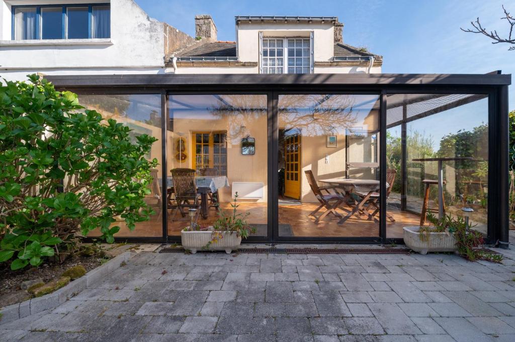 a glass extension of a house with a patio at Maison proche de la mer in Arzon