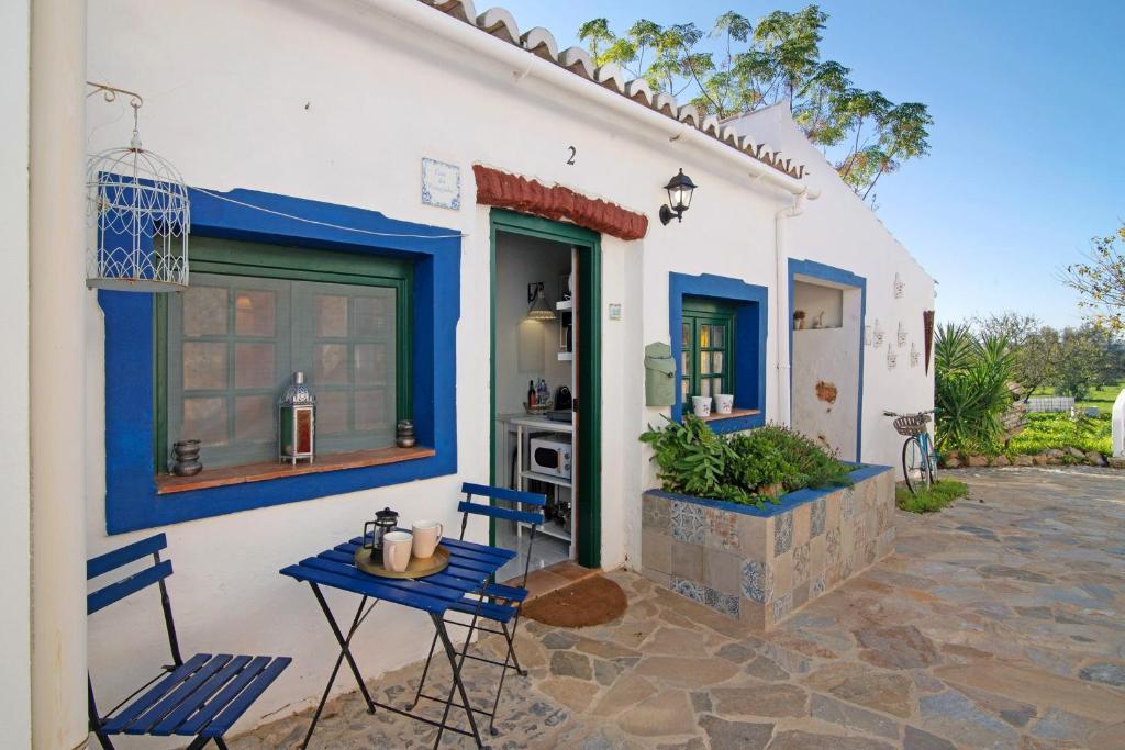 a house with two chairs and a table on a patio at Quinta do Mestre- Casa Passarinhos in Tavira