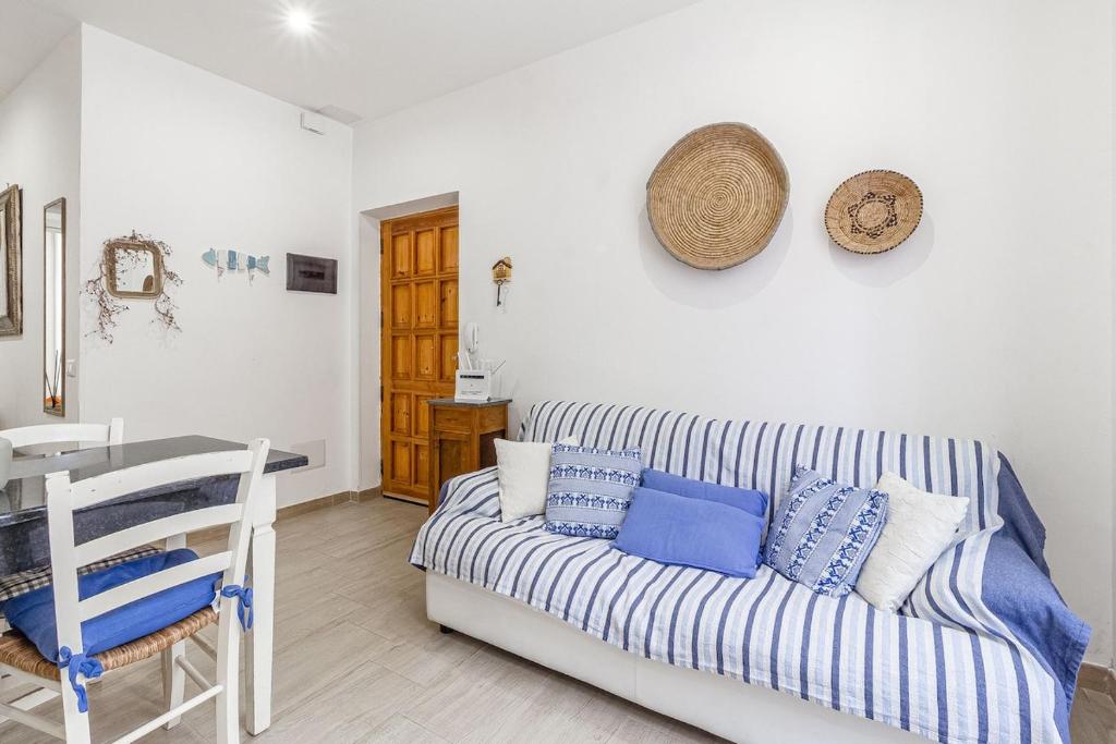 a living room with a couch with blue and white pillows at NURAS - Casa IAIA Alghero city center in Alghero