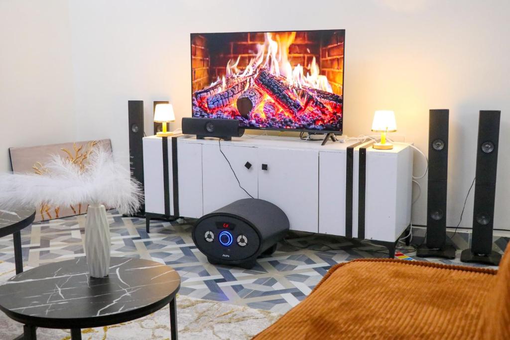 ein Wohnzimmer mit Flachbildfernseher und Lautsprechern in der Unterkunft Els BnB in Bungoma