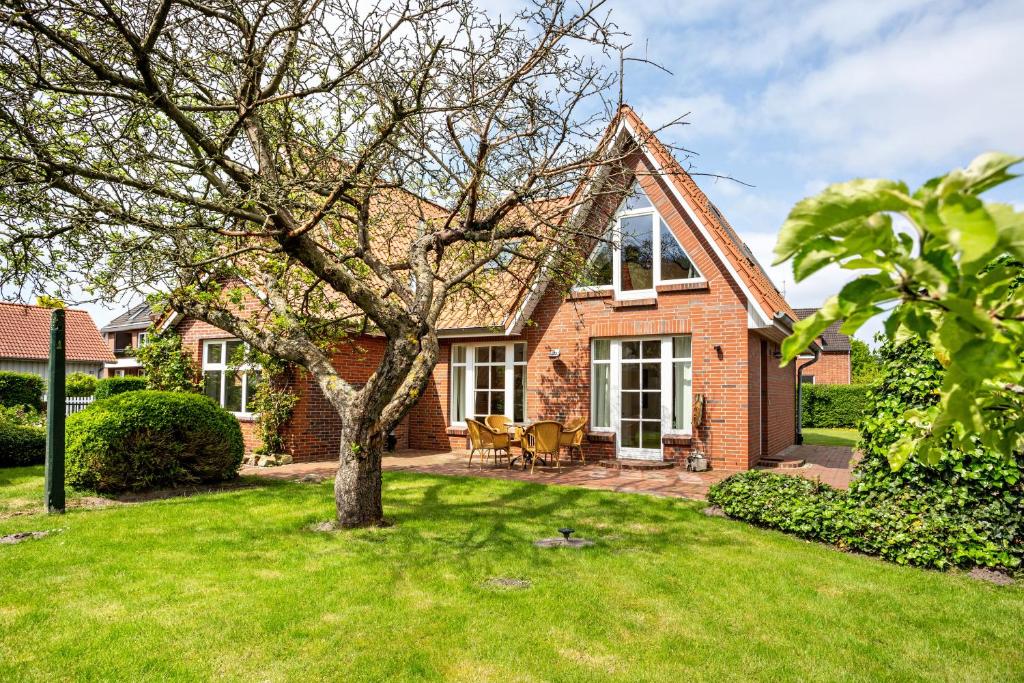 a brick house with a tree in the yard at Altes Fischerhaus II in Cuxhaven