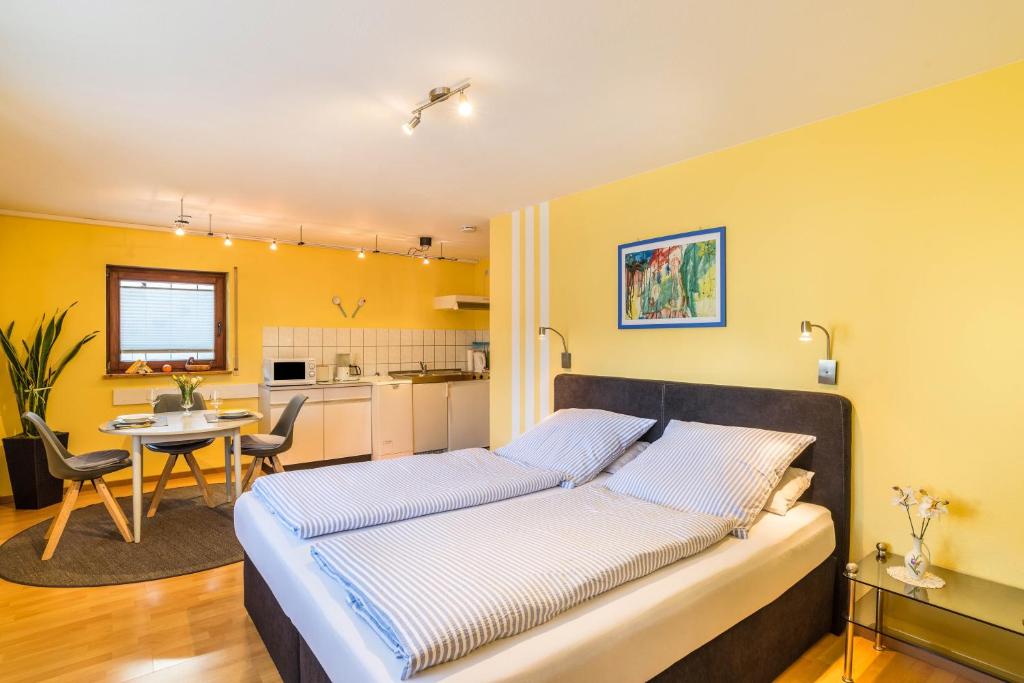 a bedroom with a bed and a table and a kitchen at Ferienwohnung Gernsbach in Gernsbach