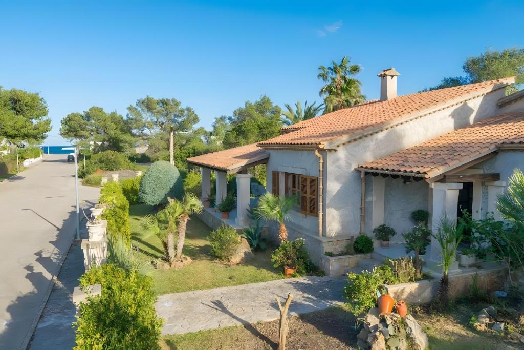 a house with a lot of plants and trees at Villa Ginebro Puerto Pollença in Port de Pollensa