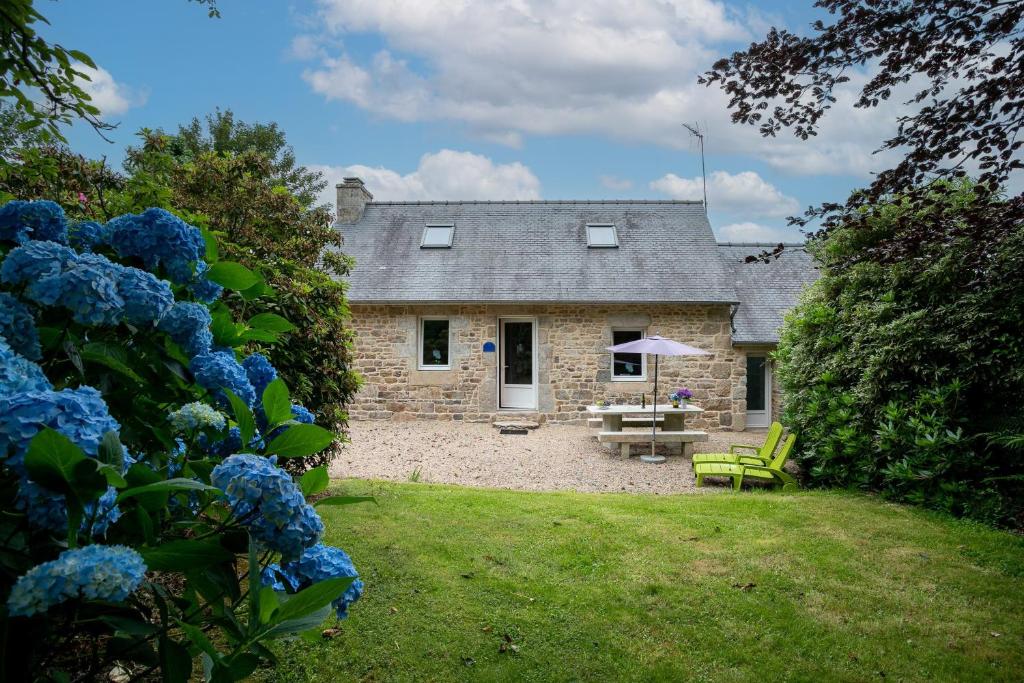 a stone house with a picnic table in front of it at Gîte Ty Nevez in Lanvellec