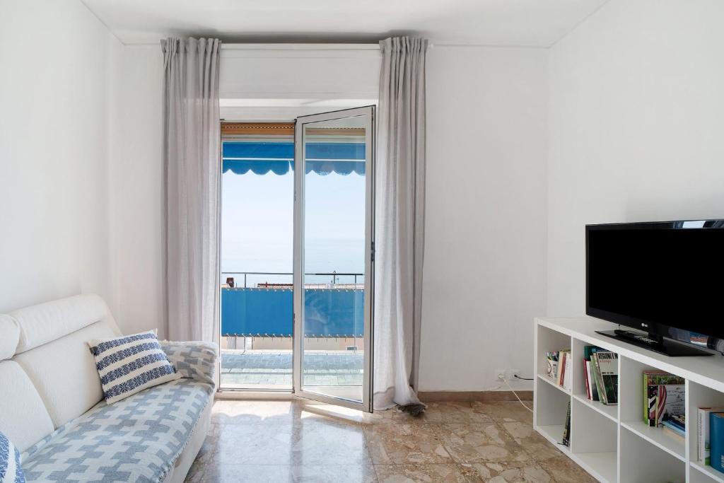 a living room with a couch and a sliding glass door at Margherita in Ospedaletti