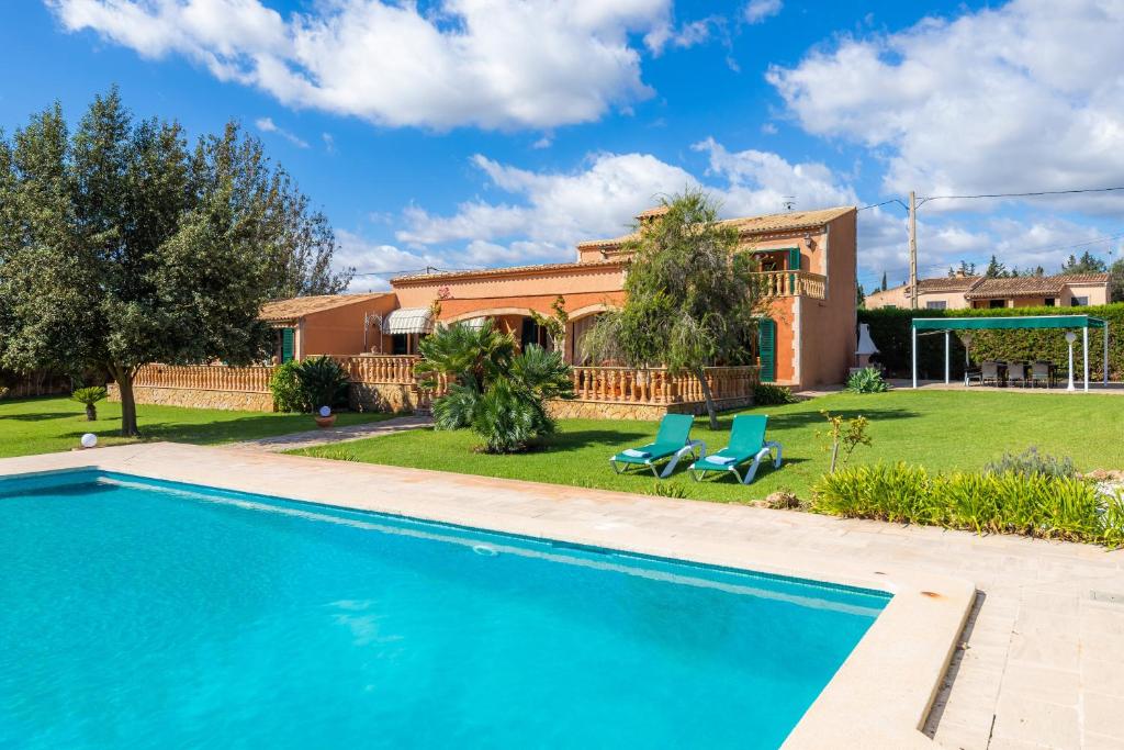 a villa with a swimming pool and a house at Es Fasser in Son Servera