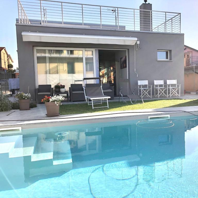 a house with a swimming pool in front of a house at Chalet al mare in Mondolfo