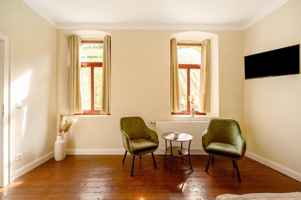 a living room with two chairs and a table at Alte Stadtvilla am Weinberg 4 in Traben-Trarbach