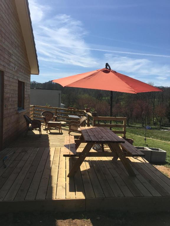 a picnic table and an umbrella on a patio at Gîte Le clos du bannet in Givonne