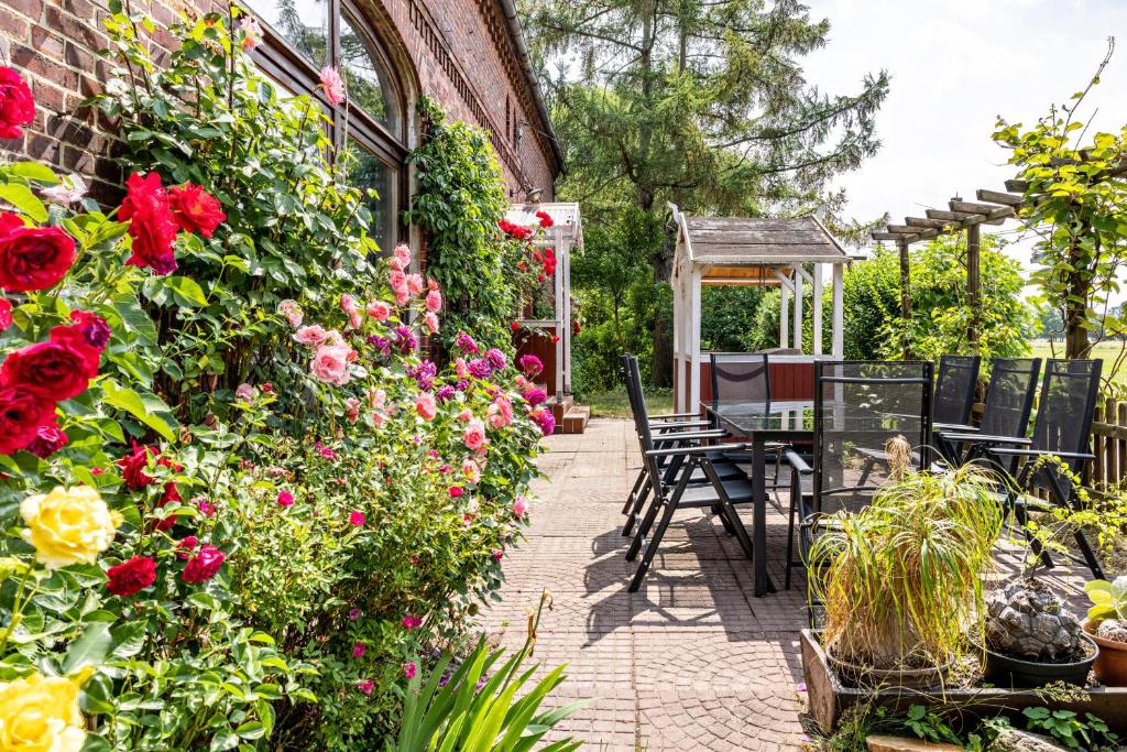 a patio with a table and chairs and flowers at Elbtalquartier im Grünen in Bleckede