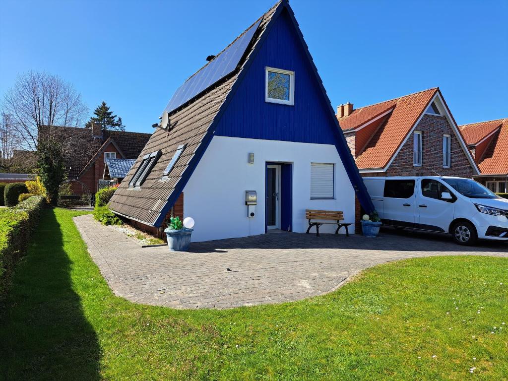 a blue and white house with a car parked in front at Haus Lotte in Wittmund