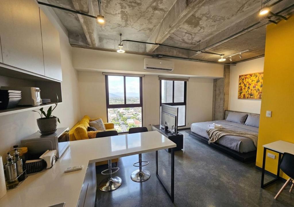 a kitchen and living room with a couch and a table at Modern loft with panoramic views in Monterrey