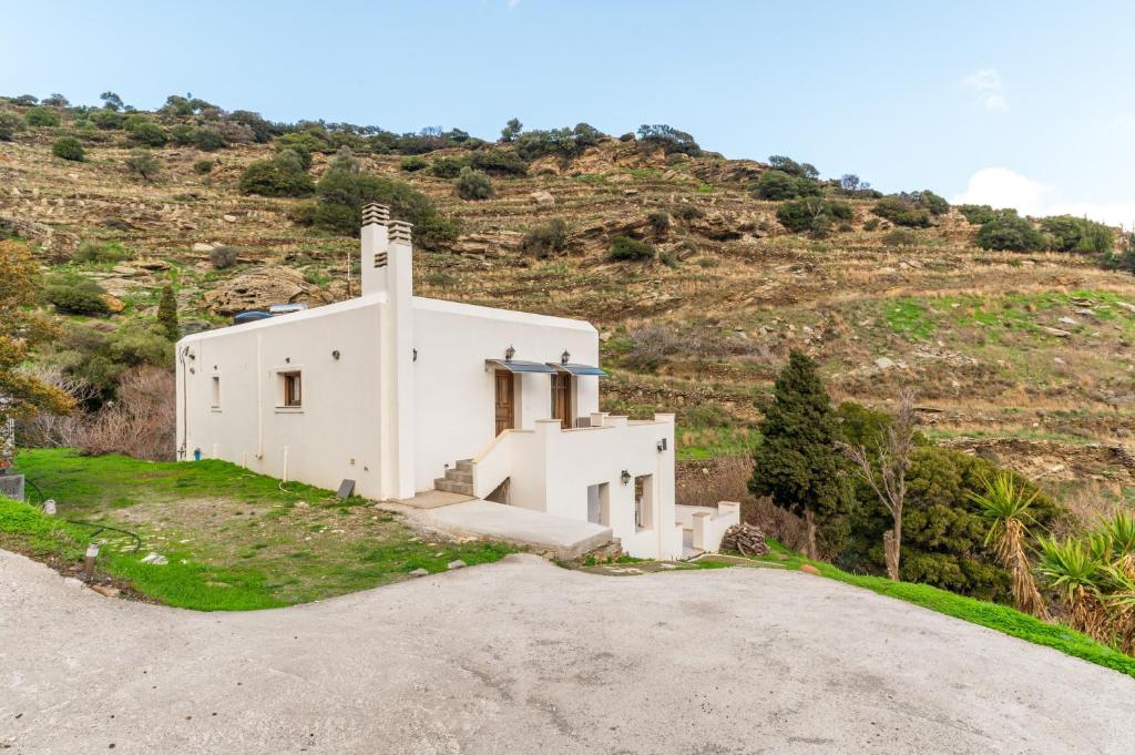 a white church on a hill with a dirt road at Moraki Apartment 2 Andros in Korthi