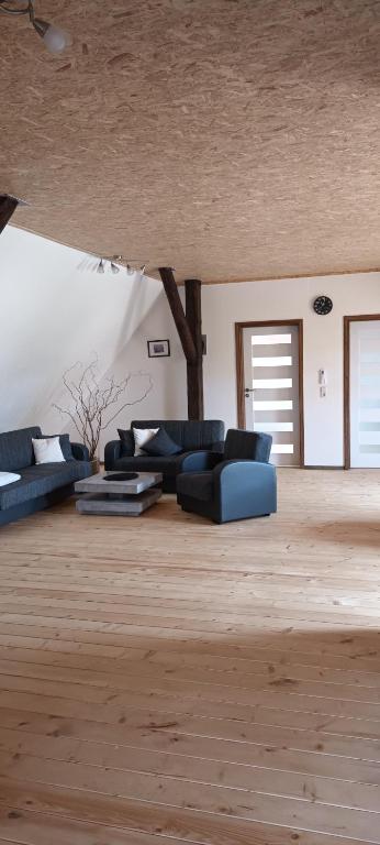 a living room with blue couches and a wooden floor at Haus beim Schloß in Woldegk