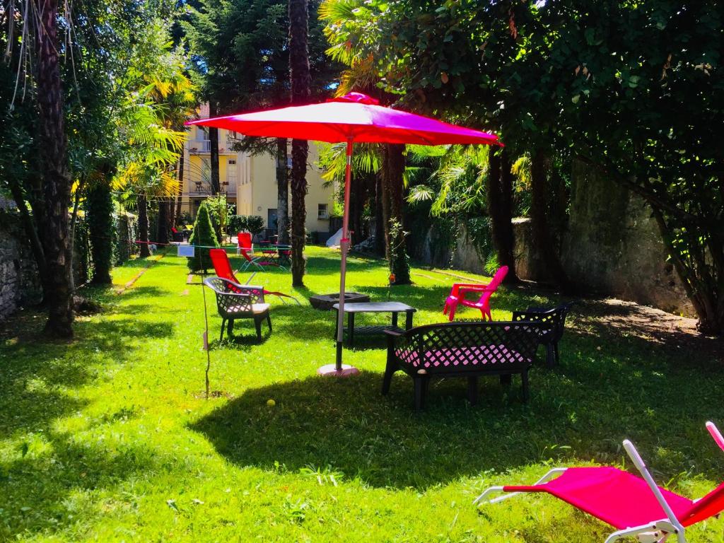 a table and chairs with an umbrella in the grass at T3 ensoleillé le Vignemale in Lourdes