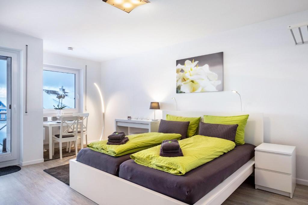 a bedroom with a large bed with yellow sheets at Schwarzwaldblick D App 8 mit Pool in Schönwald