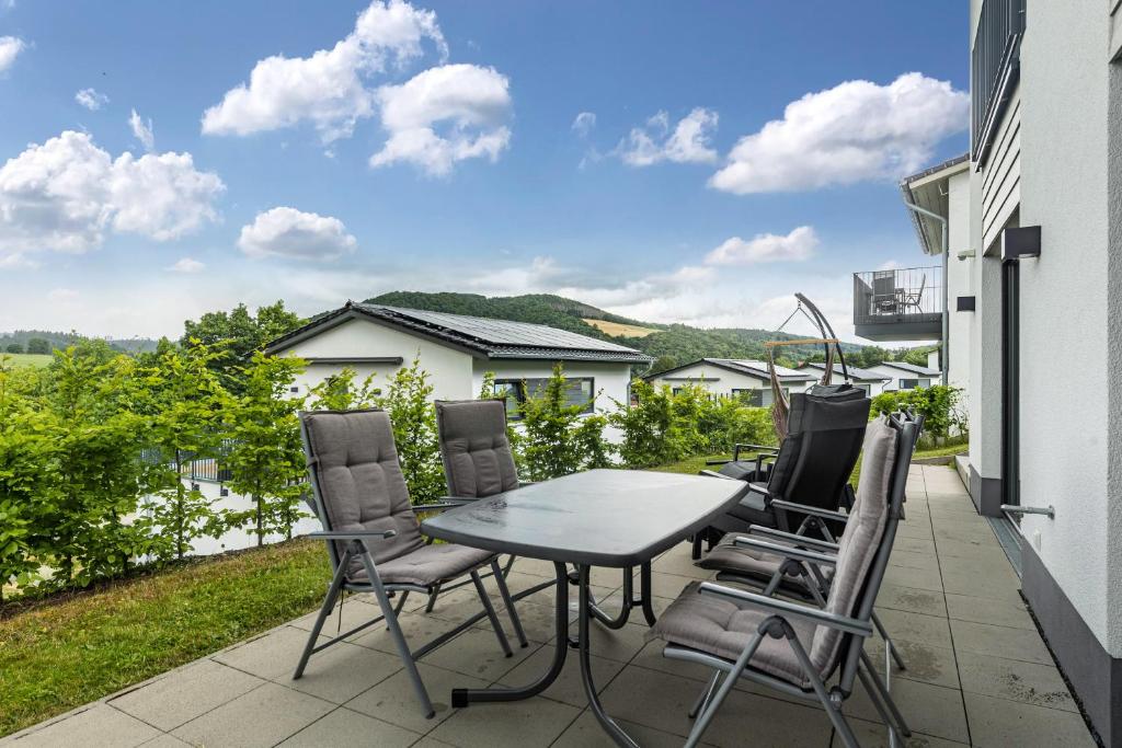 a patio with a table and chairs on a balcony at Ferienhaus Diemelblick in Heringhausen