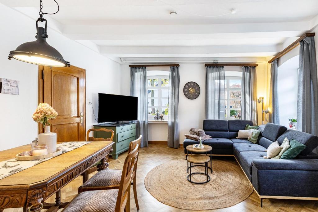a living room with a blue couch and a table at Kempers Auszeit in Plettenberg