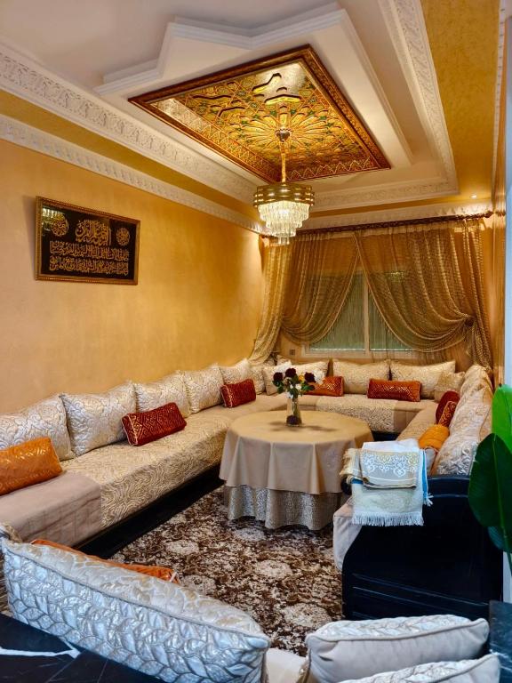 a living room with a large couch and a table at Dar dyafa in Meknès