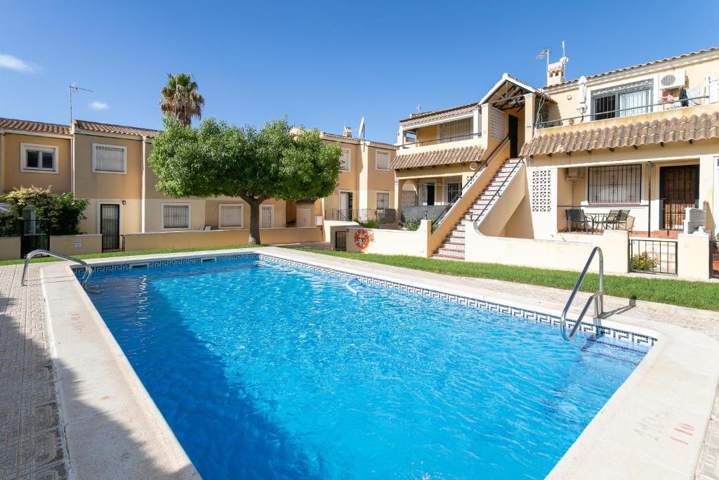 a swimming pool in front of a house at Heads 2 Holiday Homes Apartment in Villamartin