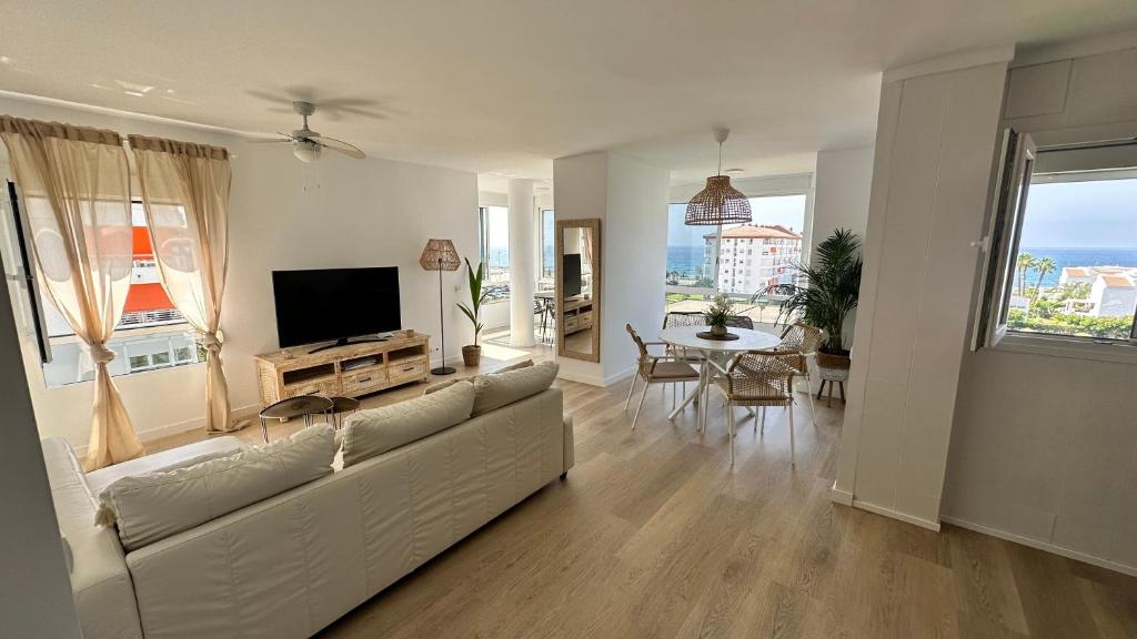 a living room with a white couch and a television at Casa Lydia in Torrox Costa