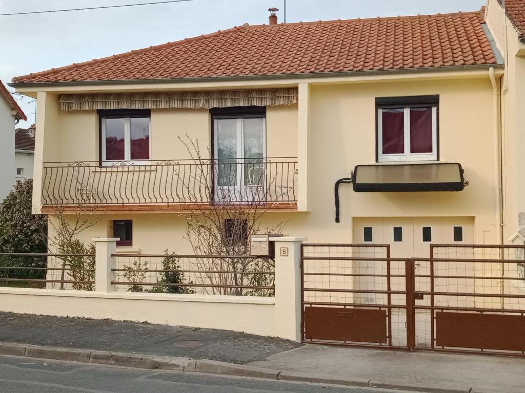 a house with a gate and a balcony at Maison entière Garage et parking in Montluçon