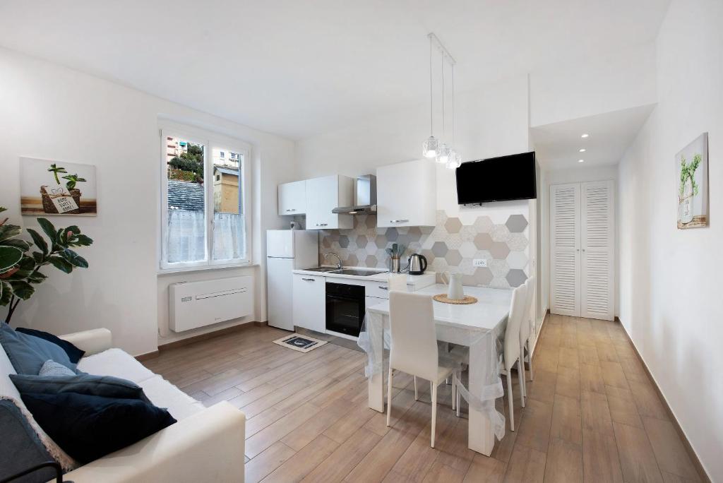 a kitchen and dining room with a table and a couch at Rosa dei Venti - Centro Storico in Varazze