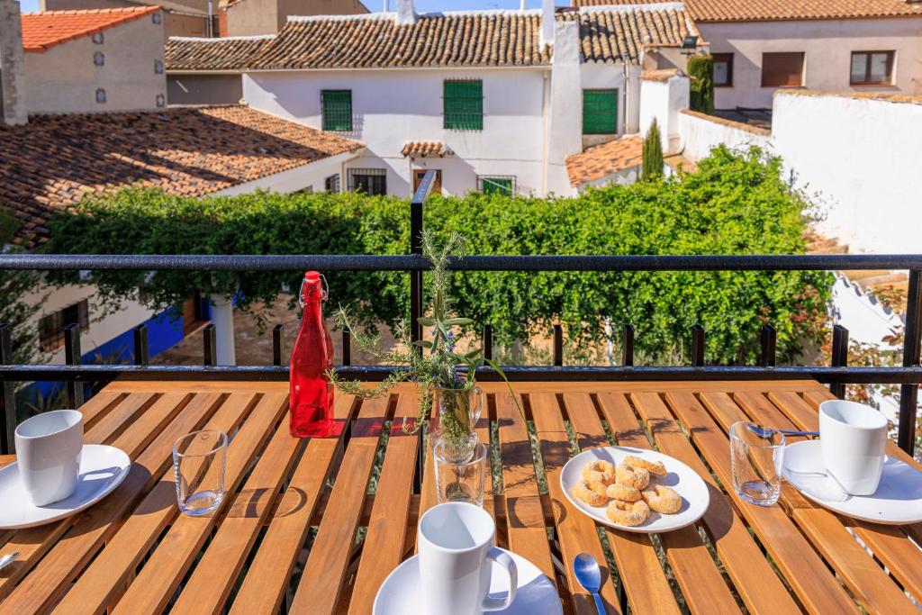 a table with a plate of food on a balcony at Apartamentos Turísticos Olivares in Mota del Cuervo