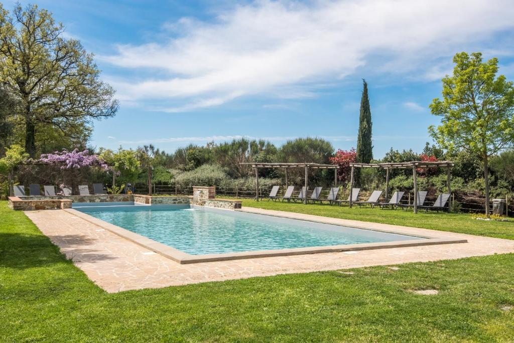a swimming pool in a yard with grass at Chalet Rosmarino in Trequanda