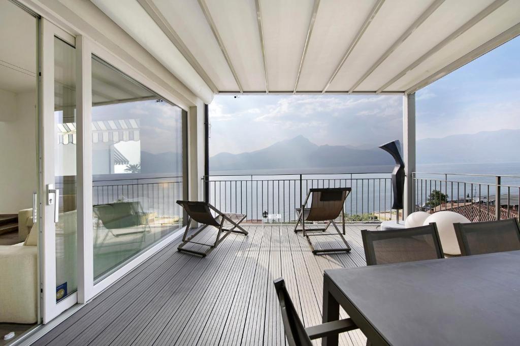 a balcony with chairs and a table and a view of the ocean at Residence La Mignon Terrazza in Torri del Benaco