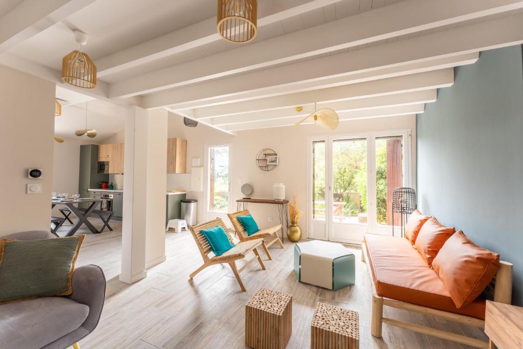a living room with a couch and chairs at Villa Rénovée, 5min Plage in Seignosse