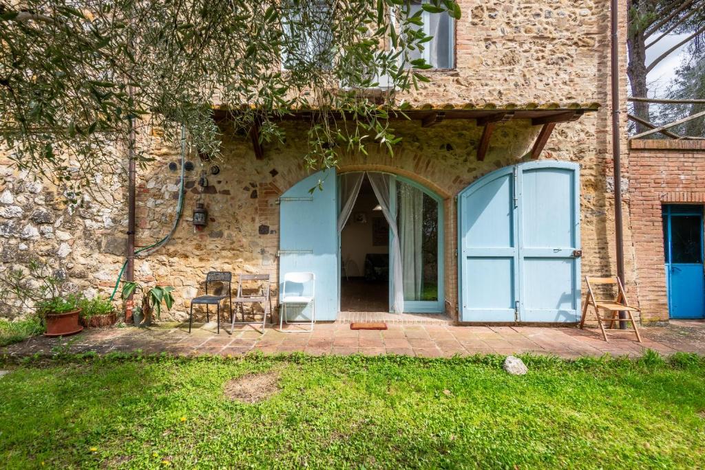 a brick house with a blue door and a patio at Nido blu loft in Siena