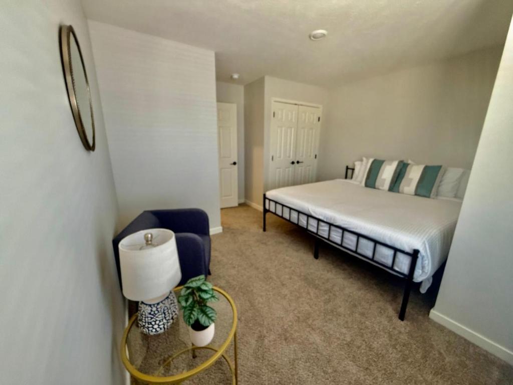 a small bedroom with a bed and a chair at The HoneyBee at Coventry Rows in Omaha