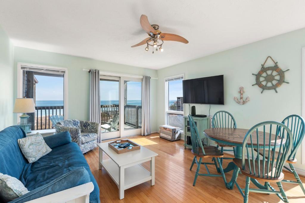 a living room with a blue couch and a table at Delightful Diversion in Duck