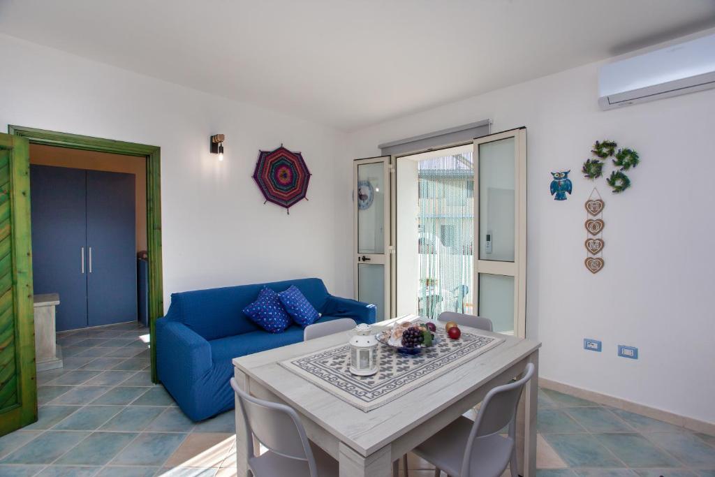 a living room with a blue couch and a table at Casa Francesco in Orosei