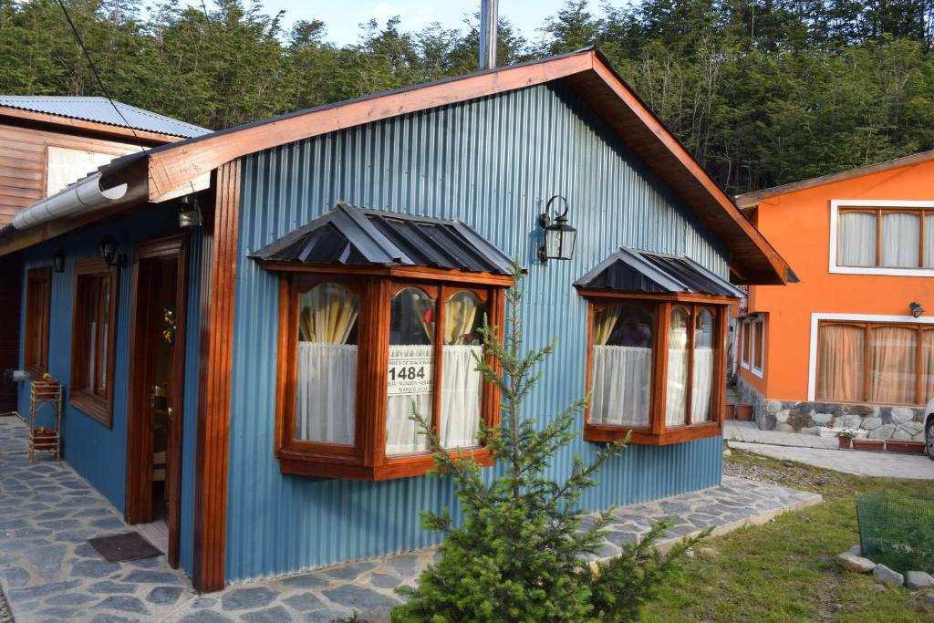 un edificio azul con ventanas laterales en Cabaña Sueños del Fin del Mundo en Ushuaia