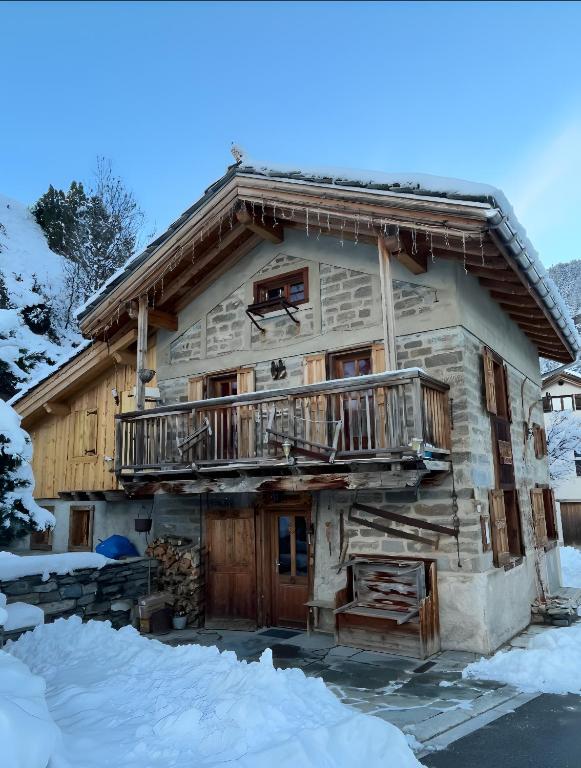 a log cabin in the snow with a balcony at Chalet Saint-Roch in Val Cenis