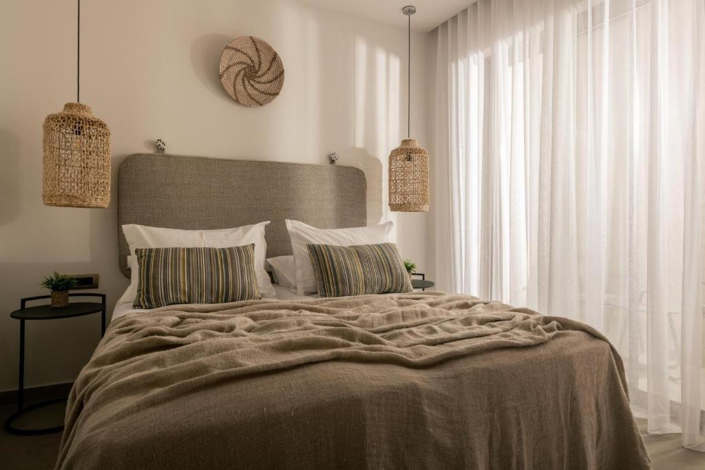 a bedroom with a large bed with two pillows at Cossoro Cave Villa in Vasilikos