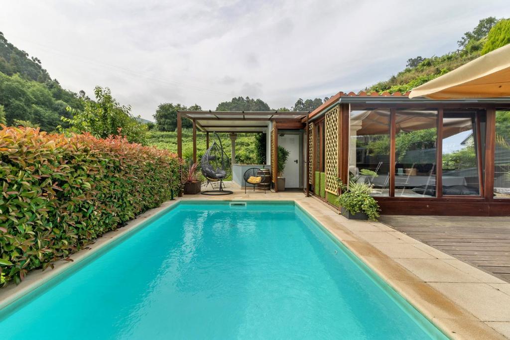 a swimming pool in front of a house at Quinta Da Cevidade in Melgaço