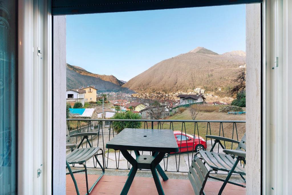 a balcony with a table and chairs and a view of a mountain at Casa Elsa in Cannobio