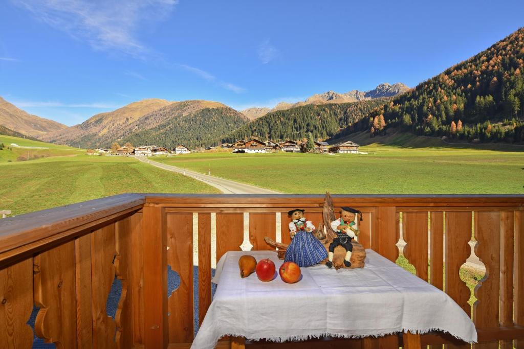 two dolls sitting on a table on a balcony at Feldererhof Gsies Apt Almenblick in Valle Di Casies
