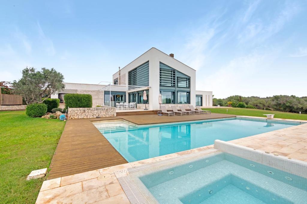 a home with a swimming pool and a house at Villa Forma Nou in Mahón
