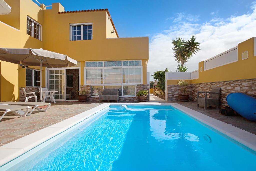 a villa with a swimming pool in front of a house at Casa Paco 3 in Costa Calma