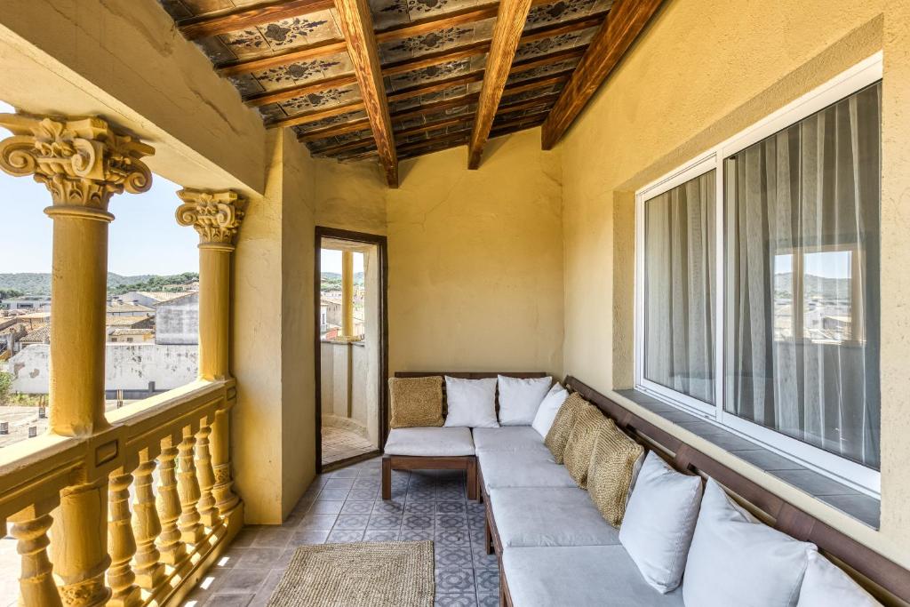a balcony with a couch and two windows at Casa señorial 14 personas -C. Brava in Palafrugell