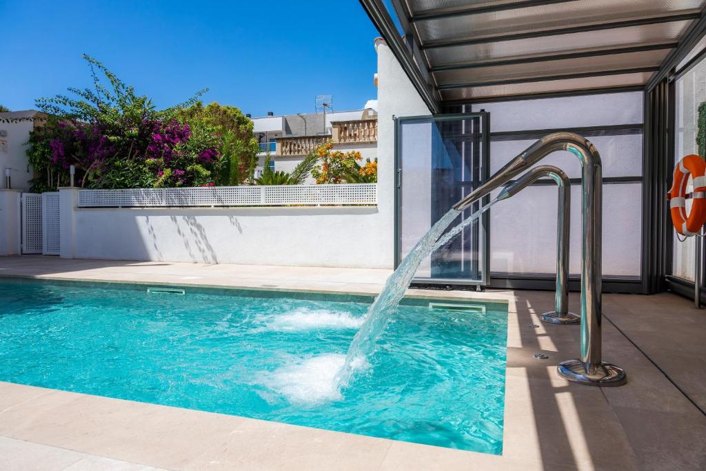 a water fountain in a swimming pool at Villa Amorós in Cala Ratjada