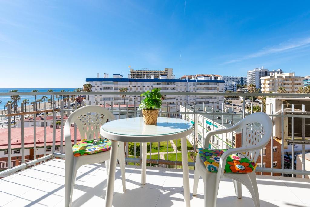 a table and chairs on a balcony with a view of the ocean at Sunny Seaside Studio in Benalmadena Costa