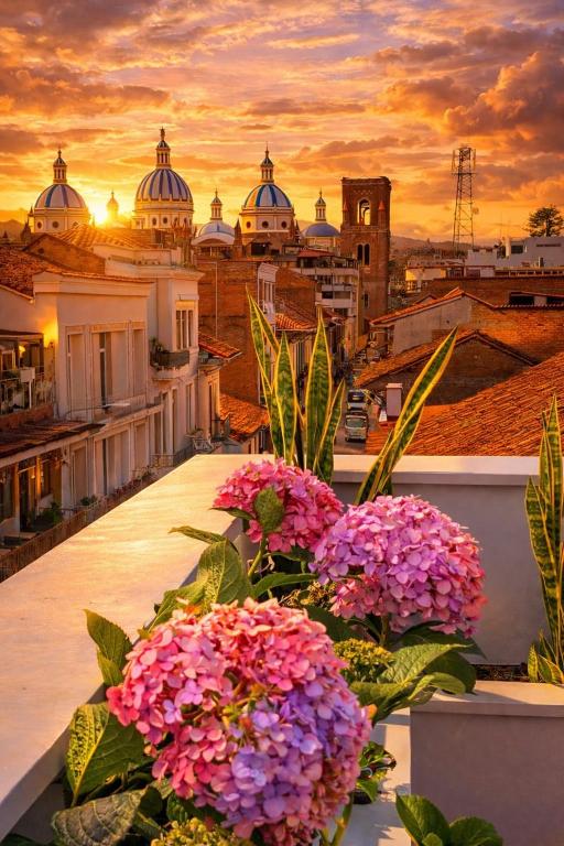 a view of a city from a balcony with flowers at Art Deco 882 in Cuenca